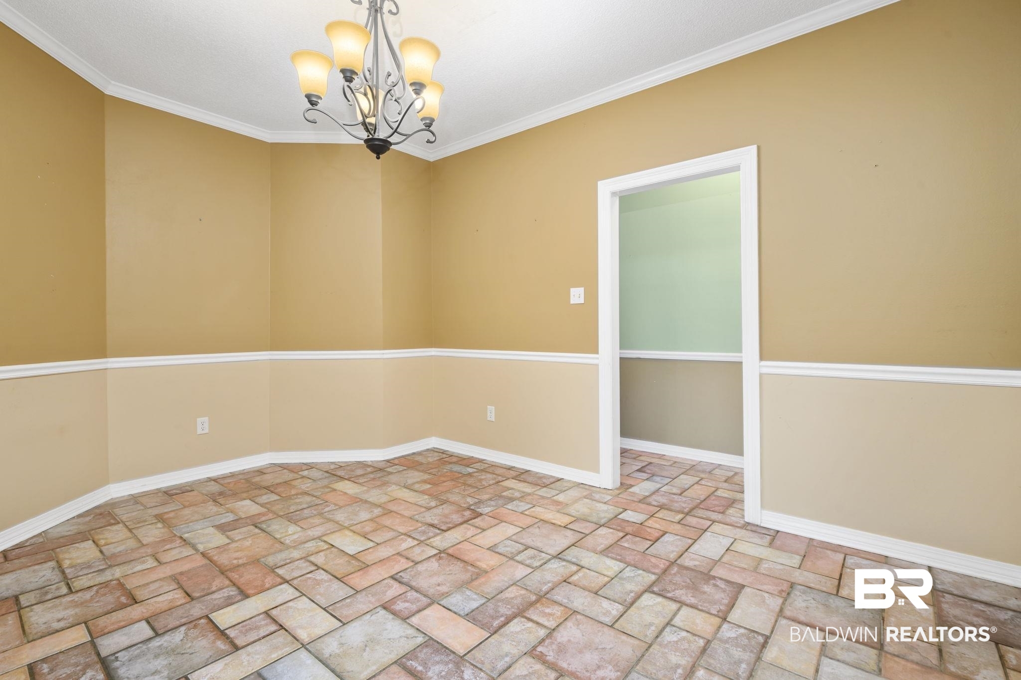 7540 2 Mile Road Irvington, AL 36544 - Photo 24 of 82 Spacious interior room featuring multi-toned tile flooring, chair rail molding, and a five-light chandelier