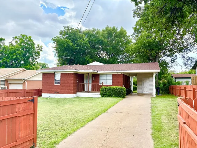 a front view of a house with a yard and potted plants