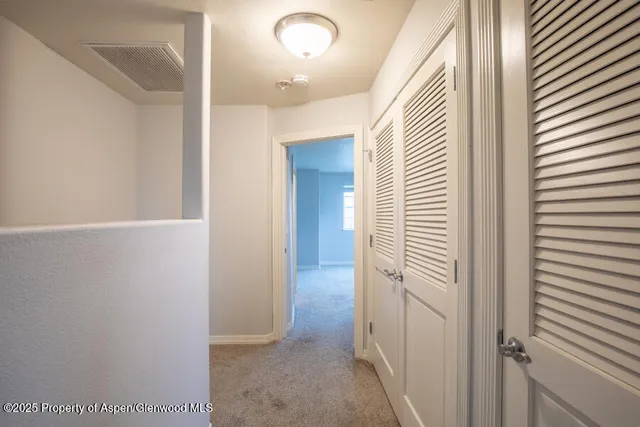 a view of a hallway with closet and bathroom