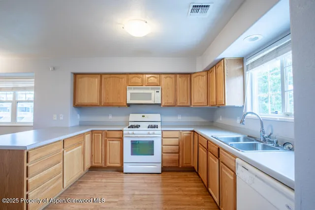 a kitchen with stainless steel appliances granite countertop a sink stove cabinets and wooden floor
