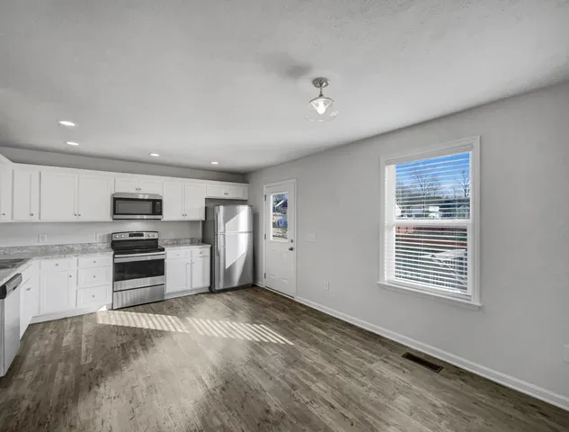 a kitchen with granite countertop a stove and cabinets