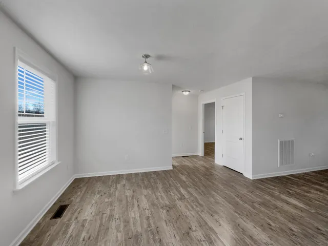 a view of a room with wooden floor and window
