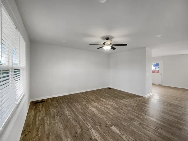 wooden floor in an empty room with a window