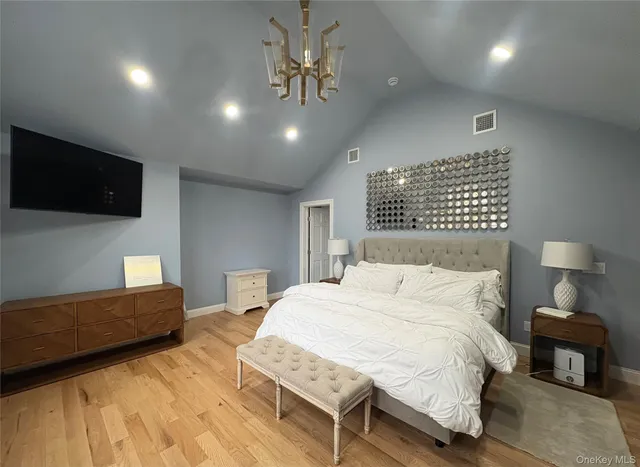 a bedroom with a bed a couch and a flat screen tv