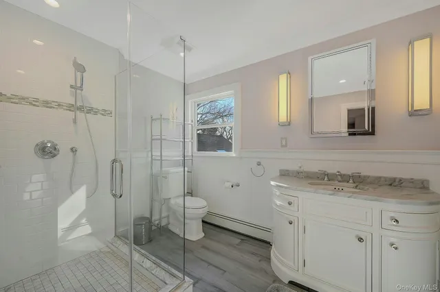 a bathroom with a granite countertop sink toilet a shower a mirror and a bathtub