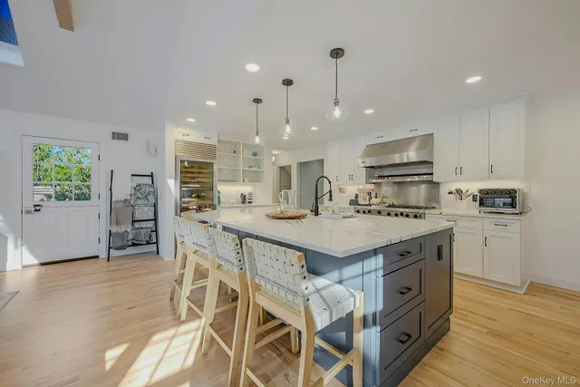 a kitchen with kitchen island a stove a table and chairs in it