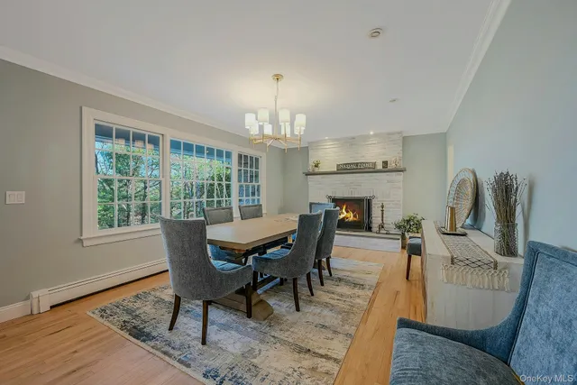 a dining room with furniture a chandelier and wooden floor
