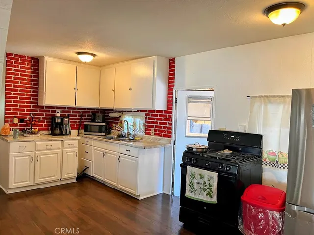 a kitchen with stainless steel appliances kitchen island granite countertop a stove a sink and a refrigerator