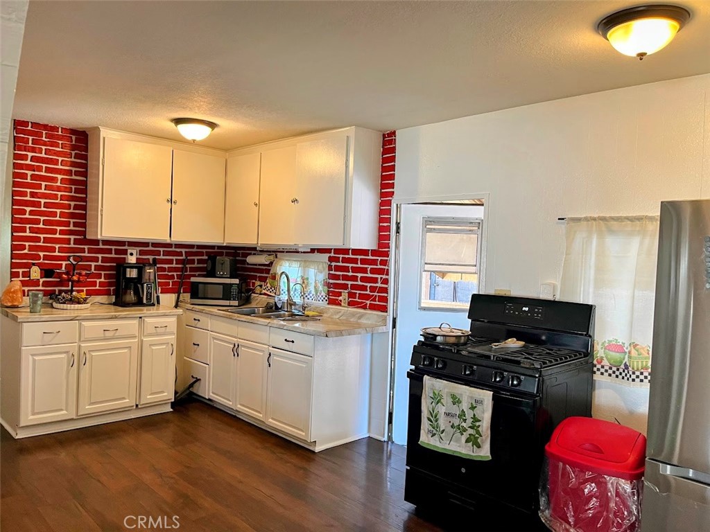 13102 Partridge Street, Unit 54 Garden Grove, CA 92843 - Photo 2 of 4 a kitchen with stainless steel appliances kitchen island granite countertop a stove a sink and a refrigerator