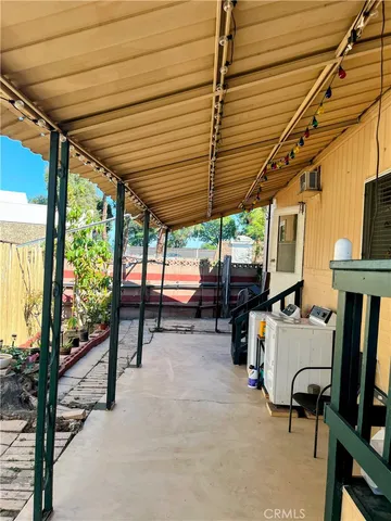 a view of a patio with table and chairs under an umbrella