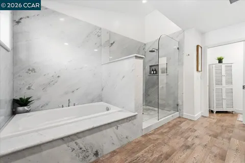 a bathroom with a toilet a sink a mirror a vanity and shower