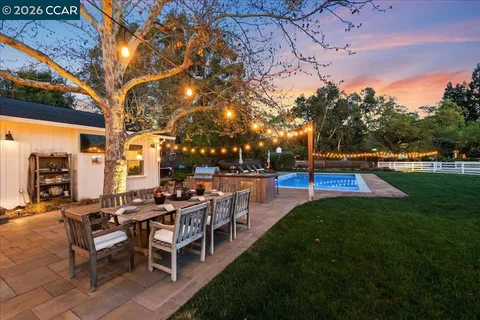 a view of a tables and chairs in patio next to a yard