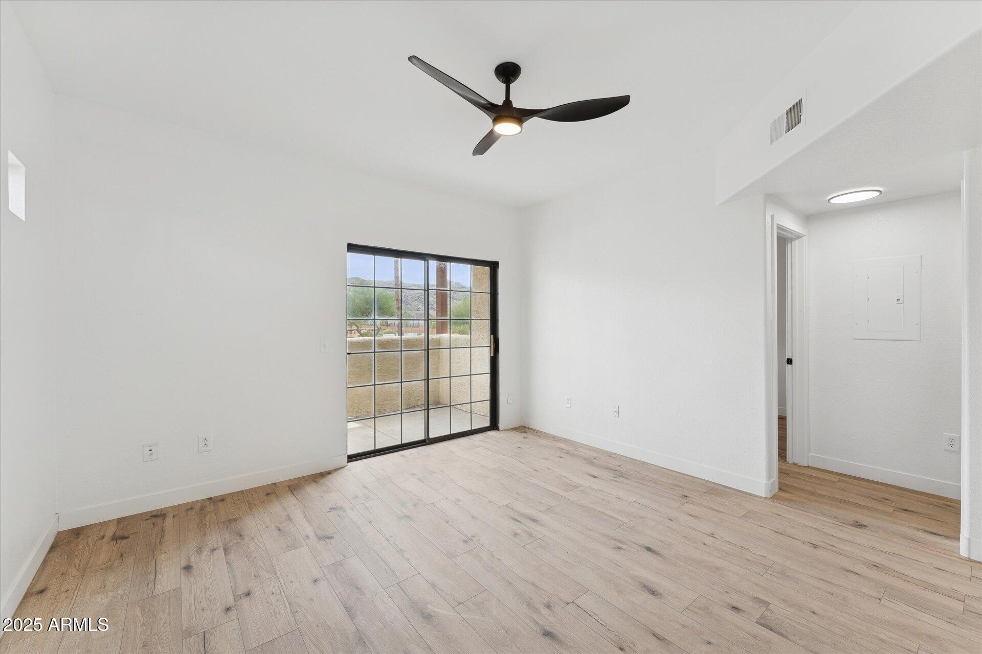 3434 East Baseline Road, Unit 265 Phoenix, AZ 85042 - Photo 4 of 19 an empty room with wooden floor and windows