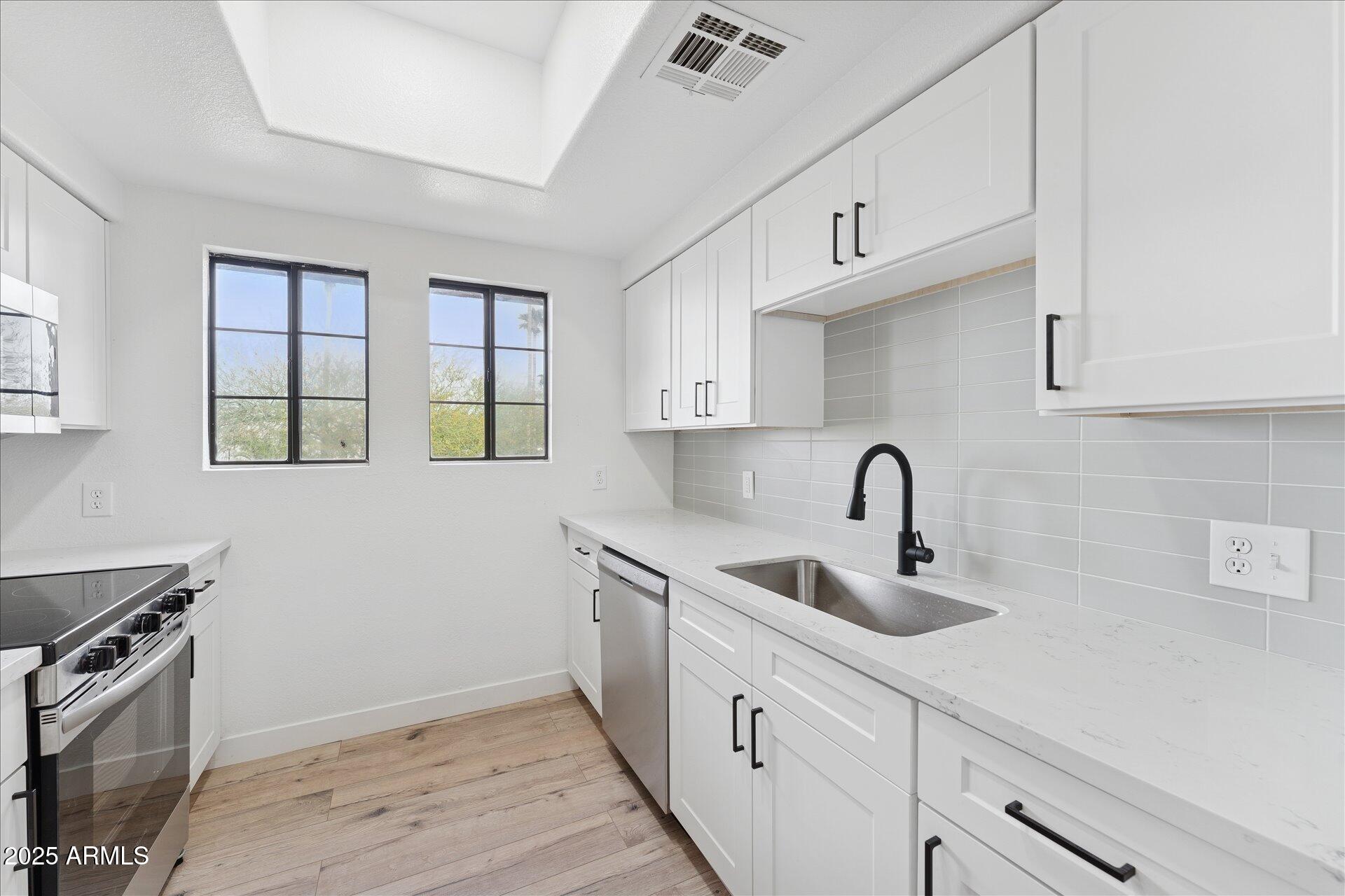3434 East Baseline Road, Unit 265 Phoenix, AZ 85042 - Photo 9 of 19 a kitchen with sink a microwave and cabinets