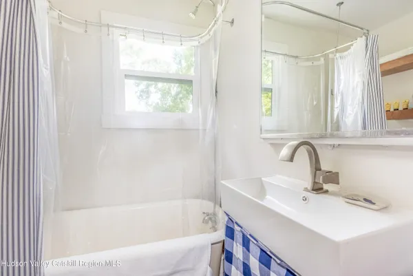 a bathroom with a sink a mirror and a bathtub
