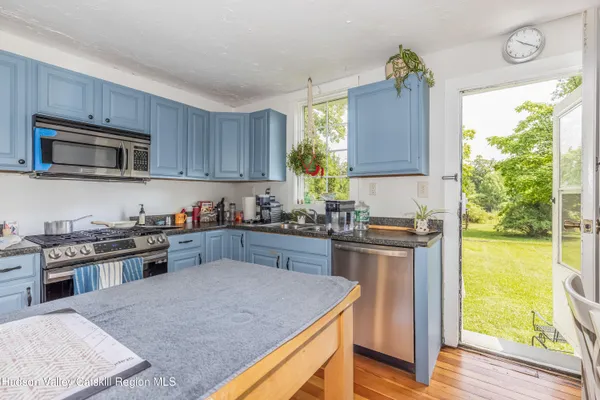 a kitchen with stainless steel appliances granite countertop a stove a sink and a microwave