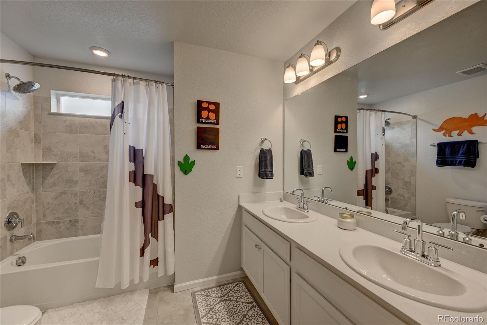 7203 Bedlam Drive Castle Pines, CO 80108 - Photo 25 of 39 a bathroom with a granite countertop sink a toilet and shower