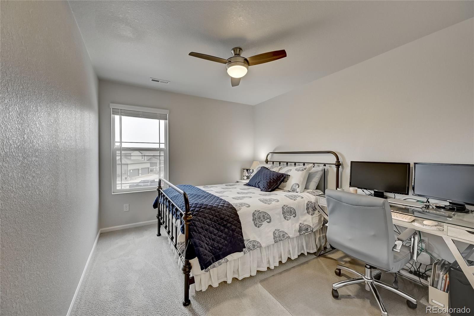 7203 Bedlam Drive Castle Pines, CO 80108 - Photo 28 of 39 a bedroom with a bed and a desk