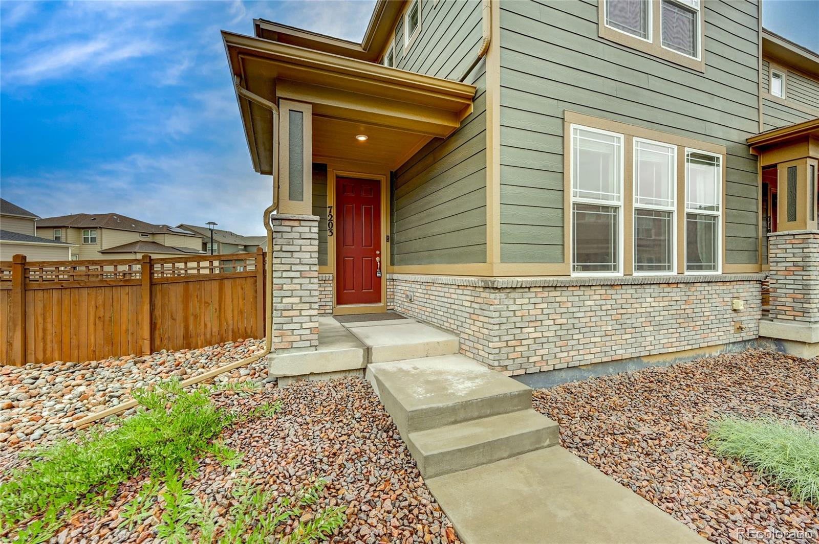 7203 Bedlam Drive Castle Pines, CO 80108 - Photo 4 of 39 a front view of a house with a yard