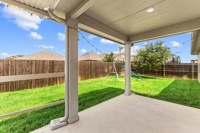 a view of a house with backyard and a tree