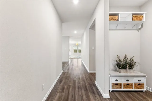 a view of a hallway with wooden floor and cabinet