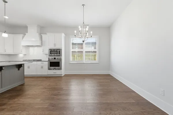 a view of a kitchen with granite countertop a stove top oven