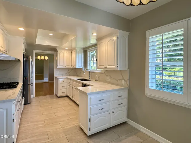 a bathroom with granite countertop a sink and a window
