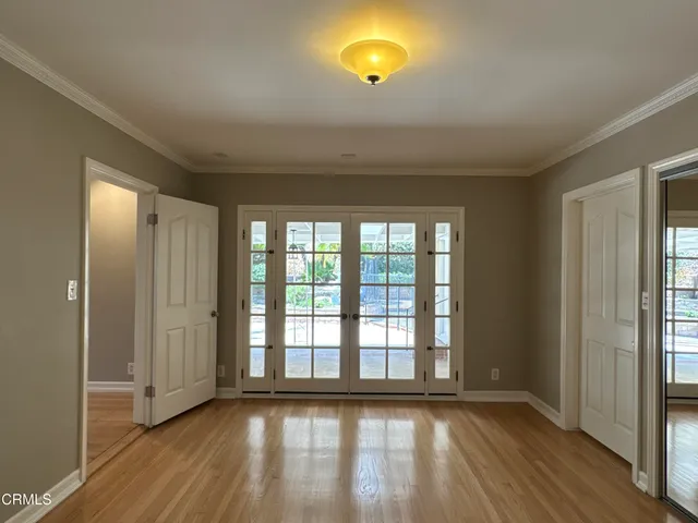 a view of empty room with wooden floor