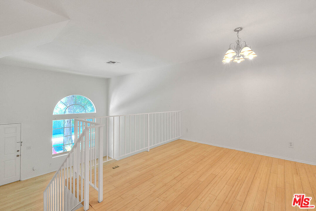 8741 Darby Avenue, Unit 16 Northridge, CA 91325 - Photo 14 of 43 a view of a room with wooden floor chandeliers and fan