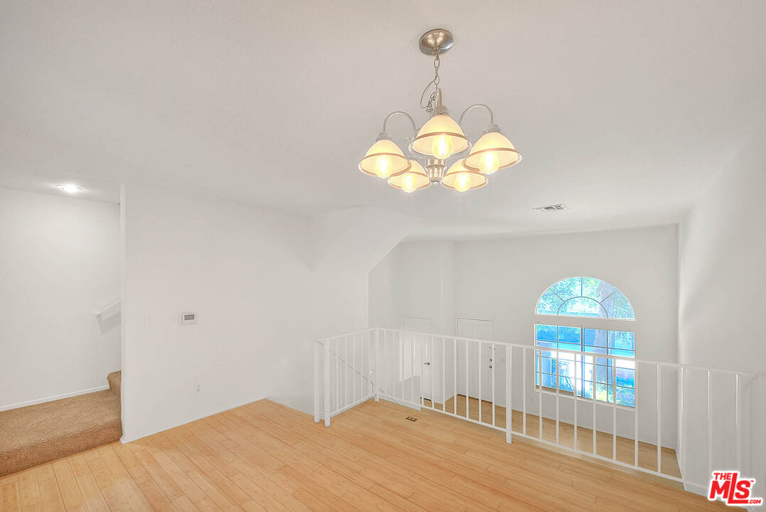 8741 Darby Avenue, Unit 16 Northridge, CA 91325 - Photo 15 of 43 a bedroom with a bed and chandelier