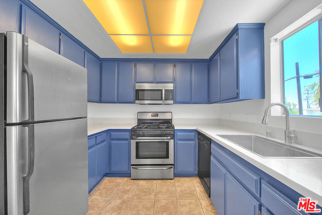 8741 Darby Avenue, Unit 16 Northridge, CA 91325 - Photo 19 of 43 a kitchen with stainless steel appliances granite countertop a refrigerator stove a sink and dishwasher