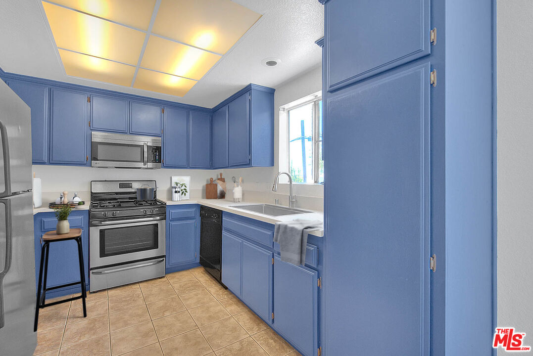 8741 Darby Avenue, Unit 16 Northridge, CA 91325 - Photo 20 of 43 a kitchen with stainless steel appliances granite countertop a stove top oven a sink and dishwasher