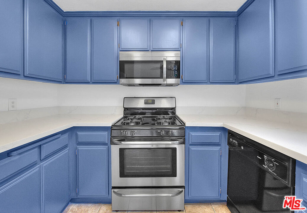 8741 Darby Avenue, Unit 16 Northridge, CA 91325 - Photo 21 of 43 a kitchen with granite countertop wood cabinets and stainless steel appliances