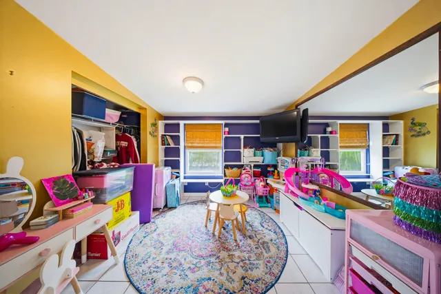 a view of swimming pool with lawn chairs and plants