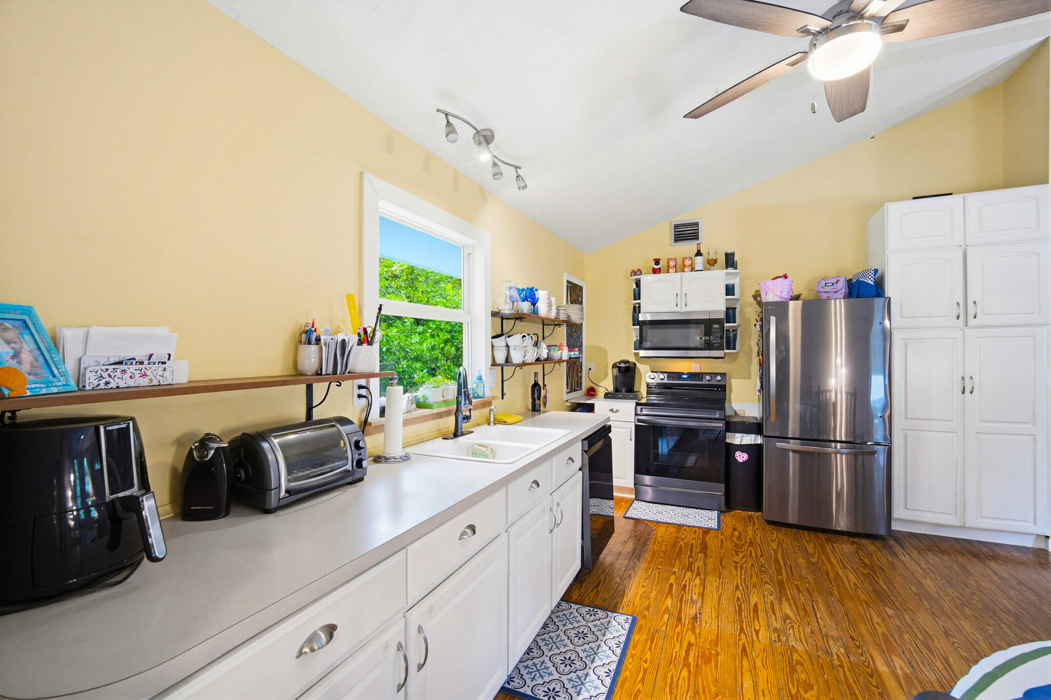 1258 Division Street Big Pine Key, FL 33043 - Photo 46 of 79 a open kitchen with stainless steel appliances granite countertop a refrigerator a stove and a refrigerator with wooden floor