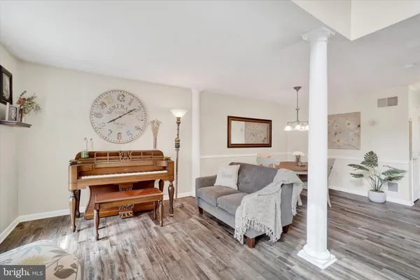 a living room with furniture a wooden floor and a bookshelf