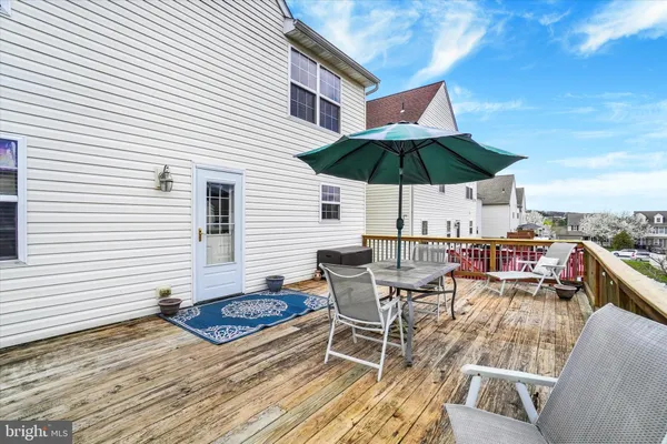 a view of a roof deck with table and chairs under an umbrella