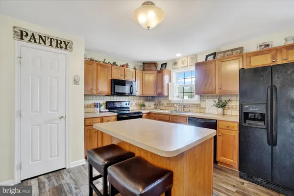 a kitchen with stainless steel appliances a refrigerator a stove a sink and a refrigerator