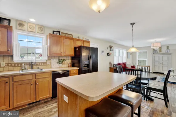 a kitchen with a dining table chairs and refrigerator