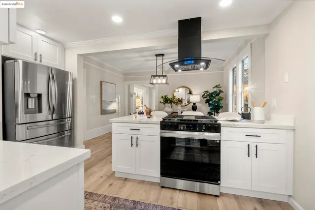 a kitchen with stainless steel appliances kitchen island granite countertop a stove and a refrigerator