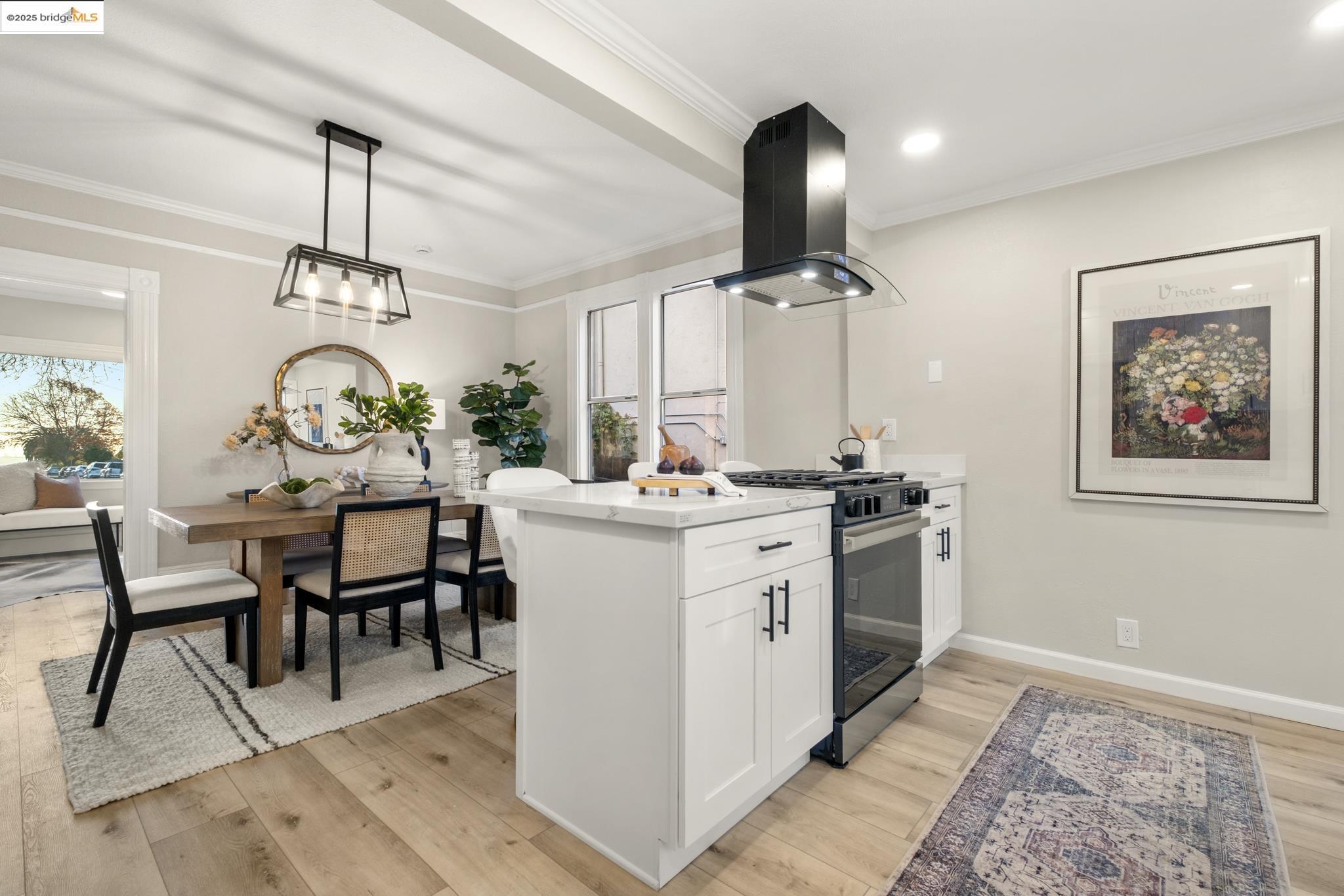 2050 East 30th Street Oakland, CA 94606 - Photo 17 of 48 Kitchen featuring gas stove, a peninsula, white cabinets, island range hood, and light wood-type flooring