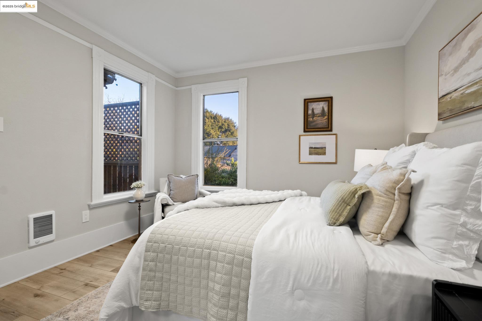 2050 East 30th Street Oakland, CA 94606 - Photo 19 of 48 Bedroom with wood finished floors, ornamental molding, and heating unit