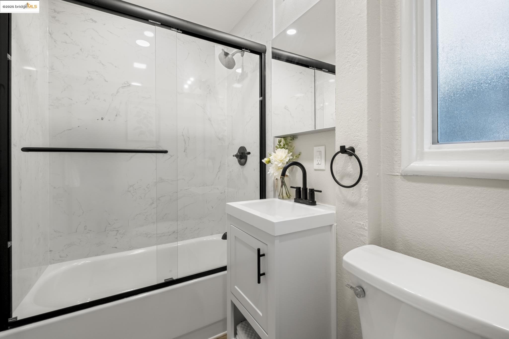 2050 East 30th Street Oakland, CA 94606 - Photo 21 of 48 Full bathroom featuring vanity, shower / bath combination with glass door, and a textured wall