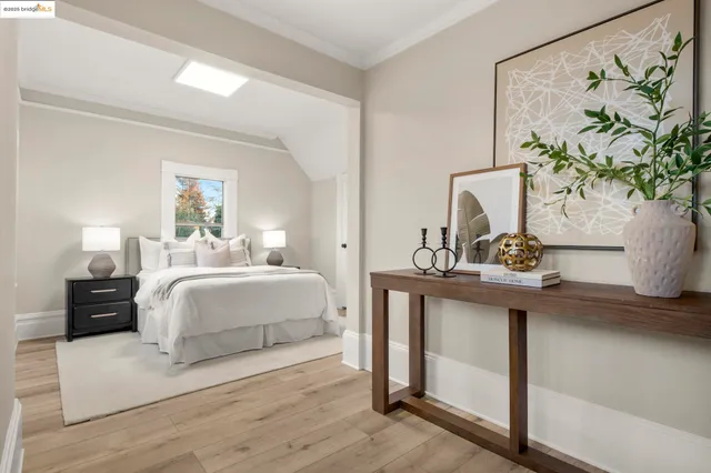 a bedroom with bed and a painting on the wall