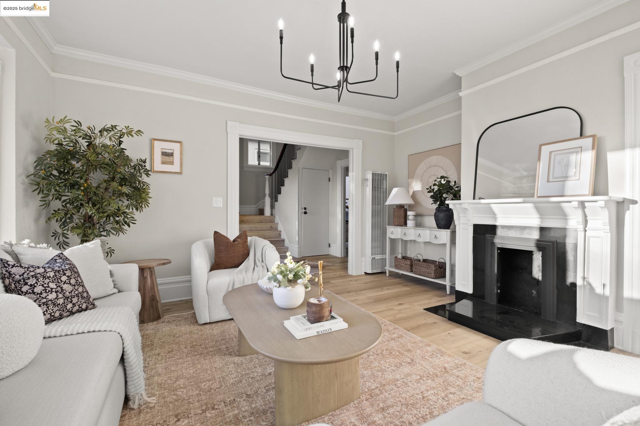 2050 East 30th Street Oakland, CA 94606 - Photo 5 of 48 Living room featuring crown molding, a fireplace, wood finished floors, a heating unit, and stairs