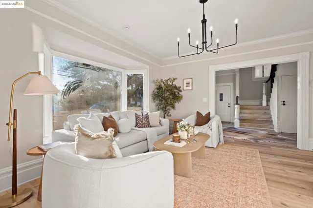a living room with furniture a chandelier and a large mirror