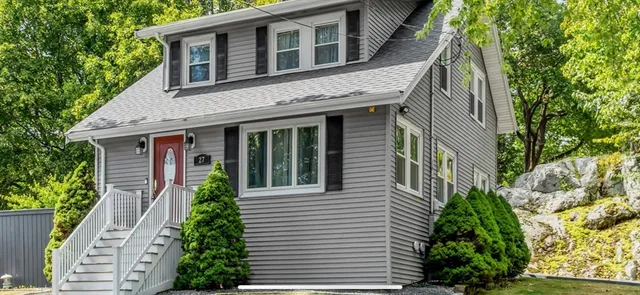 a view of a house with potted plants and a tree
