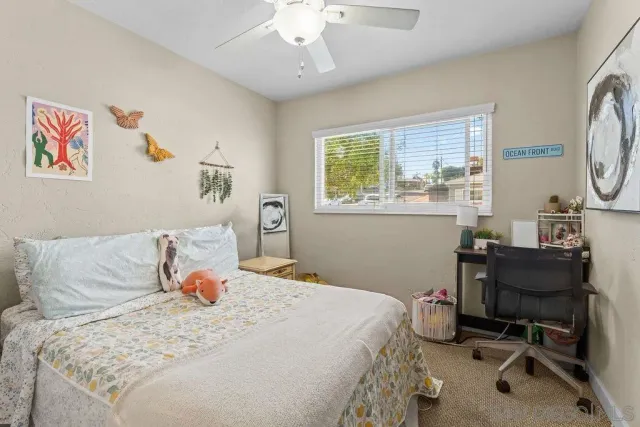 a bedroom with a bed a desk and chair with a large mirror