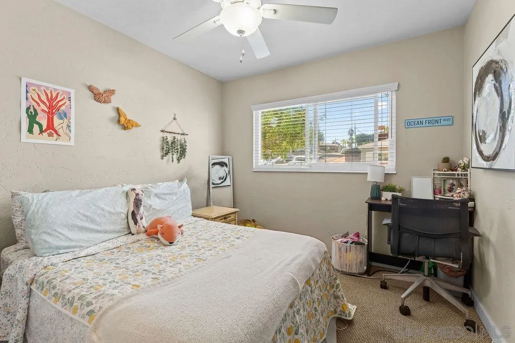 5109 Alumni Place San Diego, CA 92115 - Photo 5 of 7 a bedroom with a bed a desk and chair with a large mirror