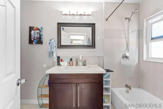 a bathroom with a sink vanity and a bathtub